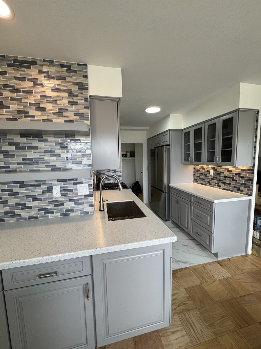 Kitchen after renovation — gray cabinets, quartz peninsula, glass tile backsplash, Glen Ridge NJ