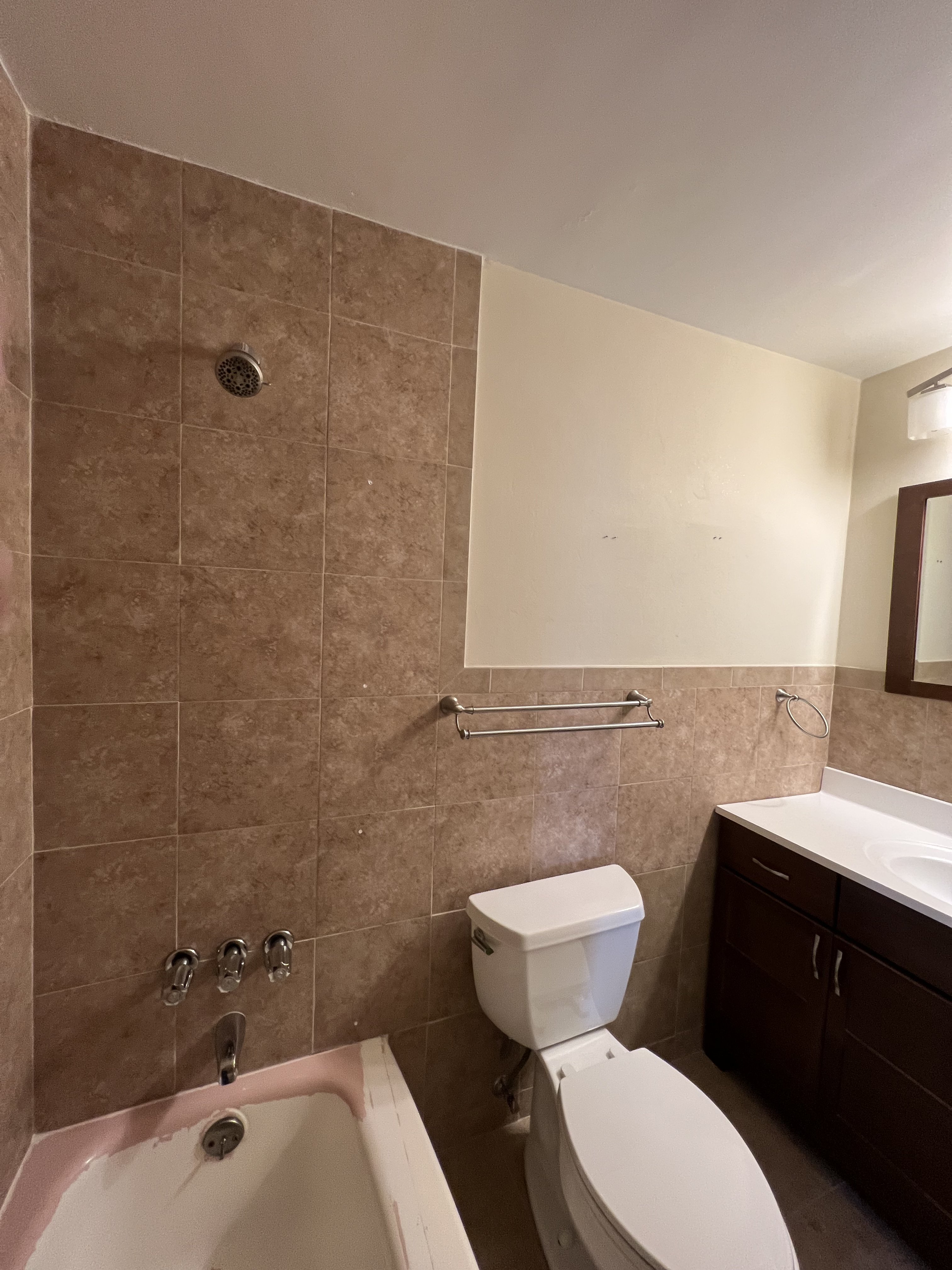 Same bathroom before renovation — worn tub and brown tile surround, Glen Ridge NJ